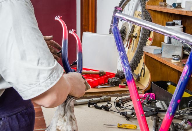 Hands of real bicycle mechanic cleaning frame bike
