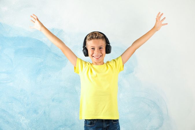 Boy with headphones against color background, space for text