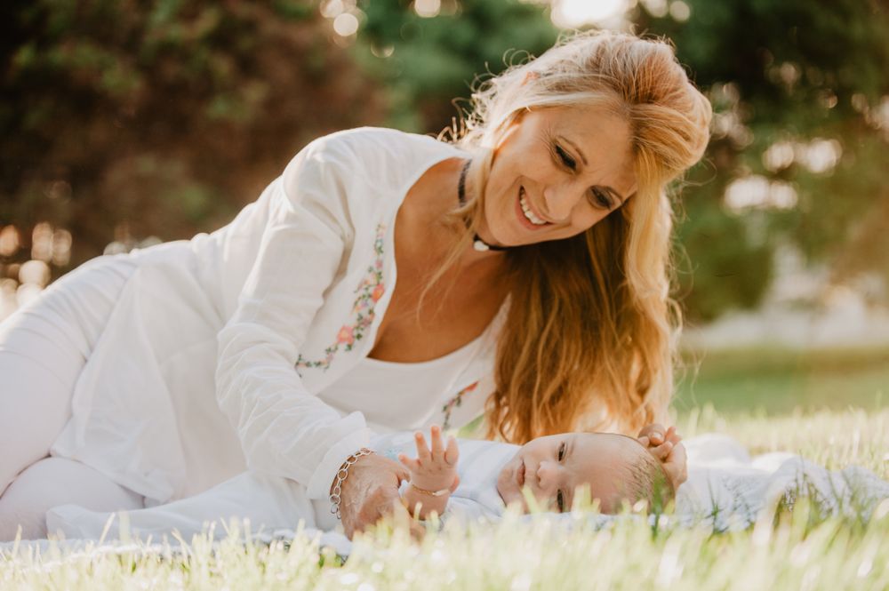 baby with down syndrome lying on a blanket with her grandmother
