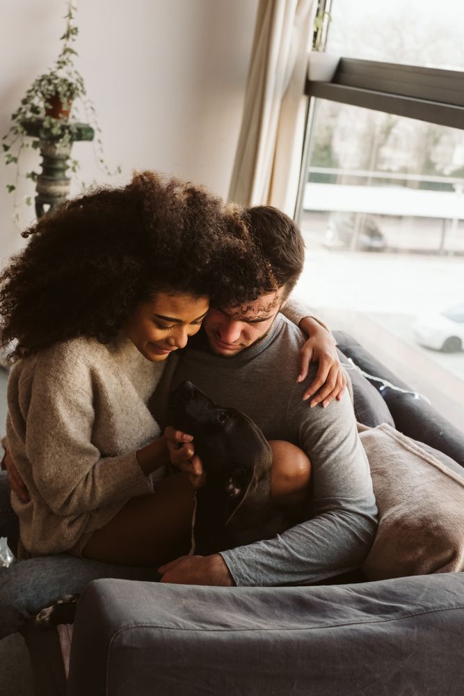 Multiethnic couple with dog on couch