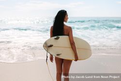 Female surfer holding surfboard at the beach 4ZOQrb