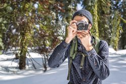 Tourist taking photo on camera while exploring nature in winter