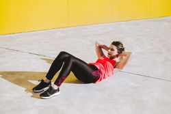 Woman doing sit ups exercises on floor