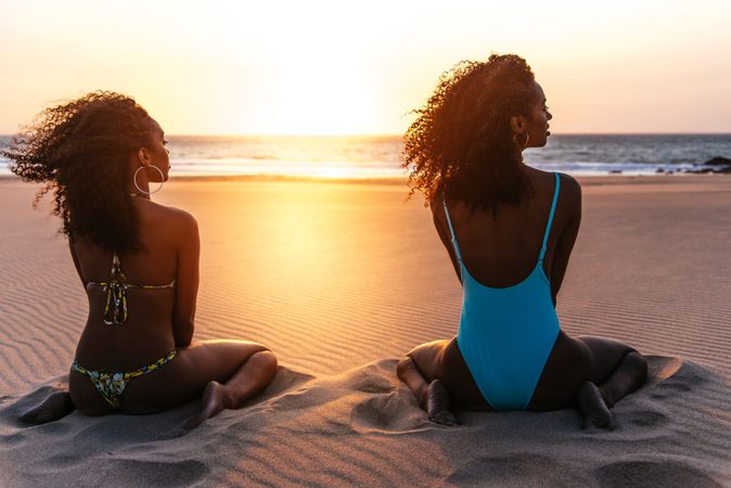 Content Black woman on tropical beach at sunset