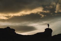 Man on mountain under beautiful sky