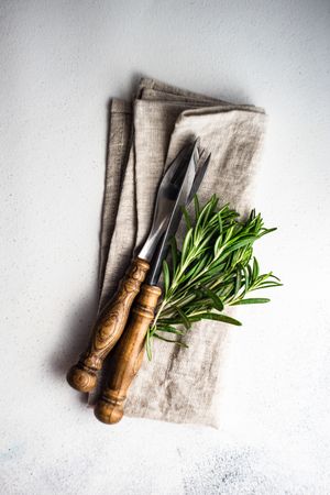 Minimalistic table setting with silverware wrapped with rosemary