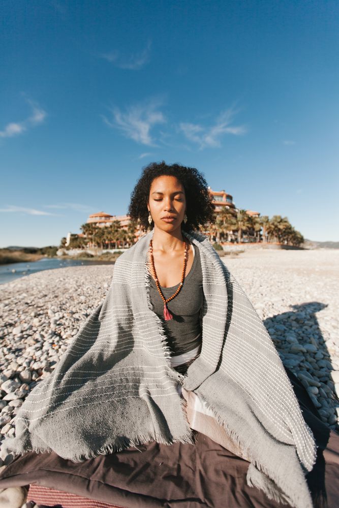Sportive woman sitting on sandy beach in asana