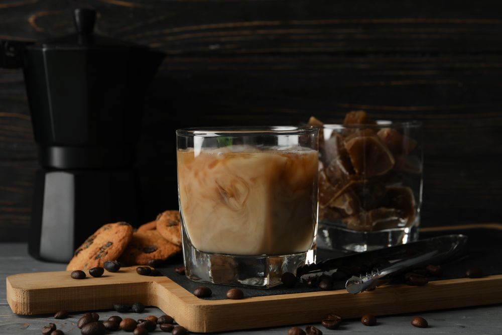 Composition with ice coffee and cookies on wooden background