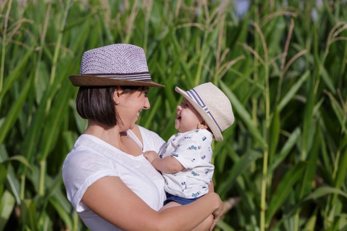 Adorable mother and child on hand enjoying and laughing in field