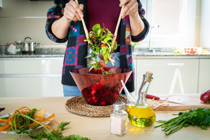 Crop woman preparing vegetable salad