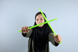 Female Muslim doing Poundfit Rockstar Workout with Green Stick