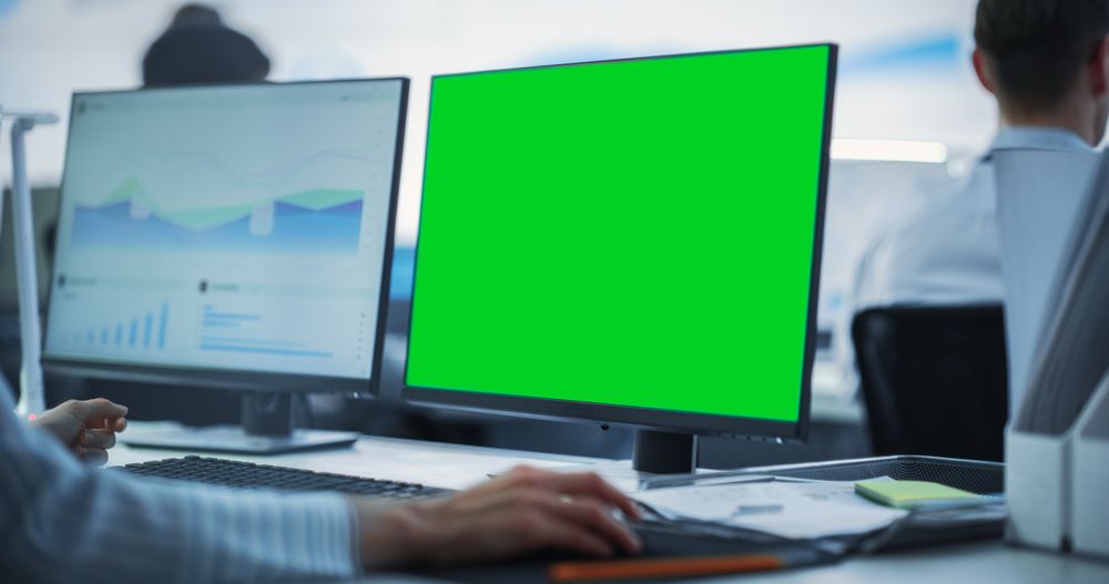 Close Up on Computer Monitor Green Screen Display in a Business Office.