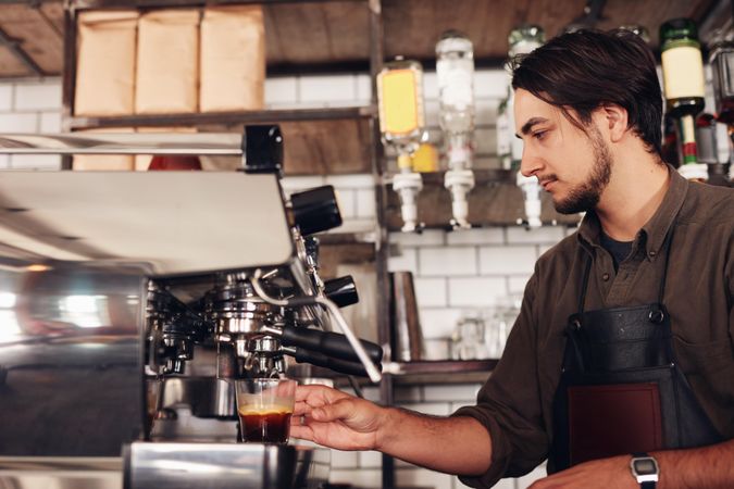 Side view of male barista preparing an espresso