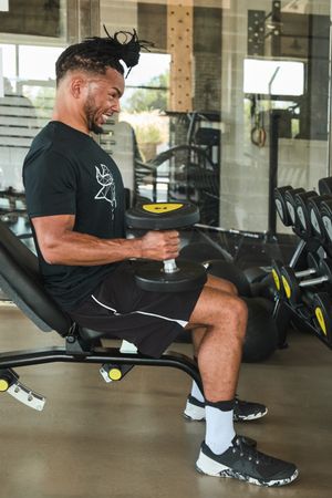 Strong man exercising with dumbbells in gym