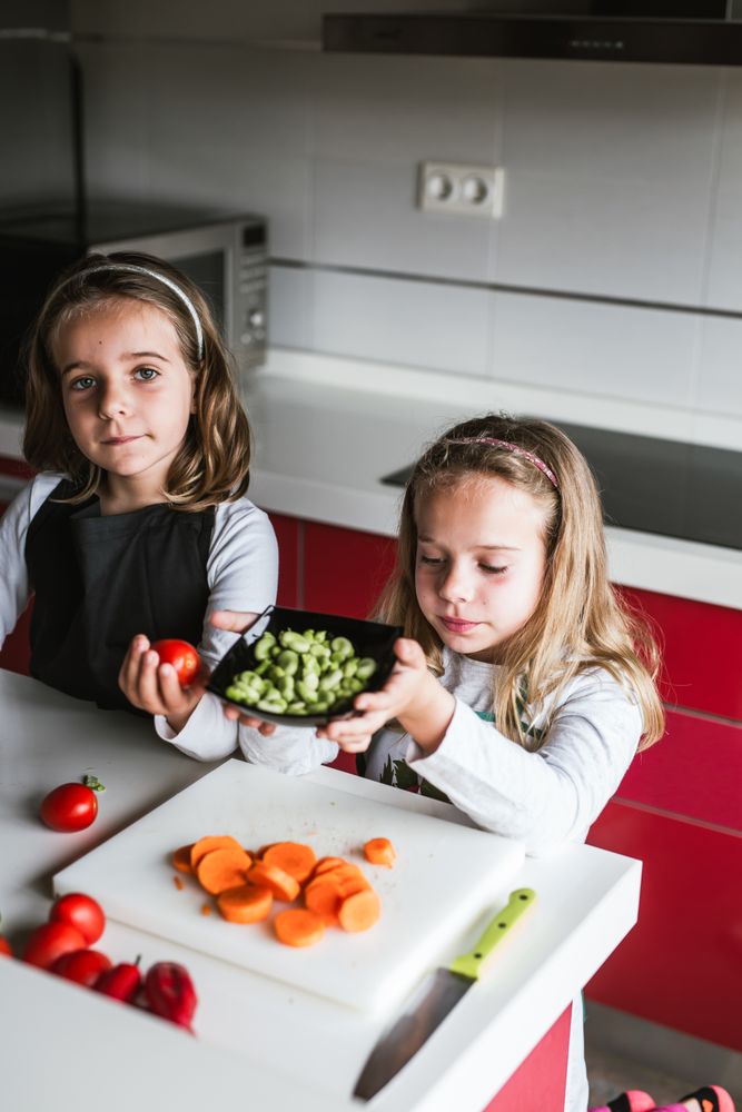 Siblings preparing vegetables for salad