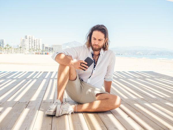Man using smartphone on beach