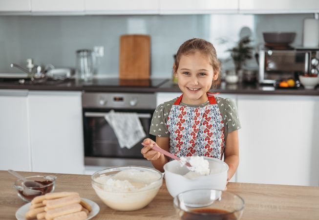 tiramisu making process in the kitchen- little girl making dessert
