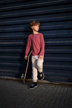 Little skater resting near wall