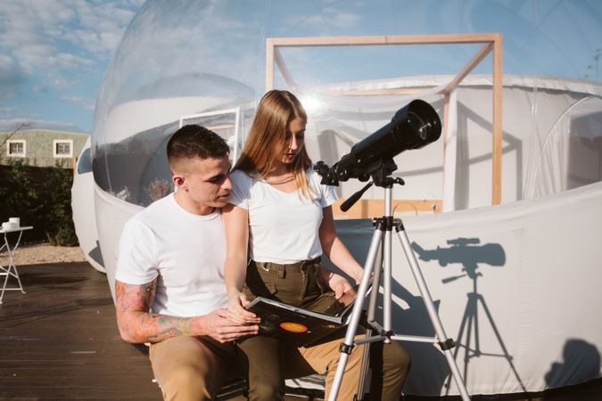 Young couple using astronomical telescope