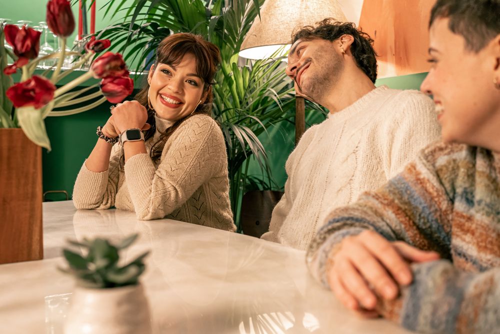 Happy woman in a candid moment, smiling with friends in a cozy bar or at home