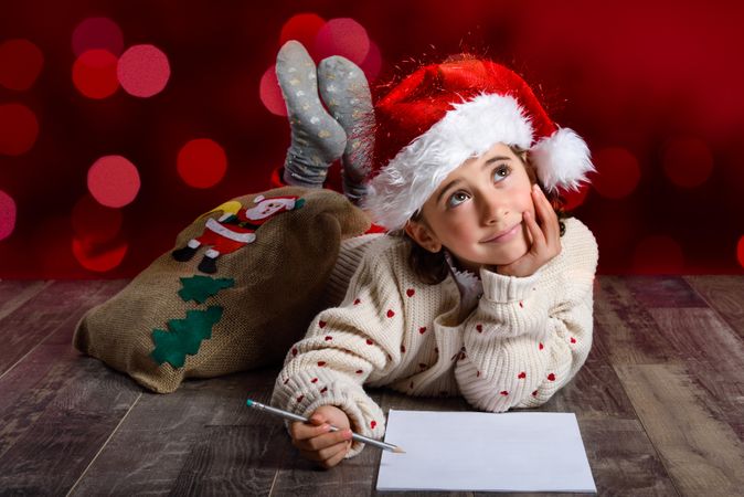Child thinking about writing a letter to Santa at Christmas time
