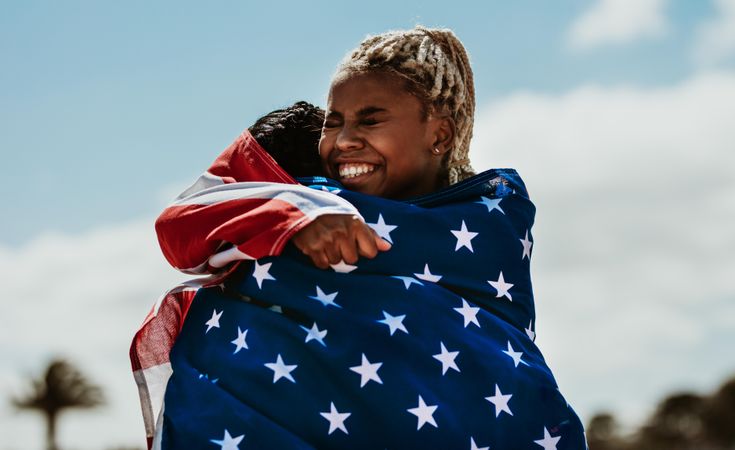 Two American woman athletes giving a hug to another after winning the competition