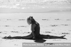 Woman doing splits on sand on a Spanish beach in b&w 49QeQ4