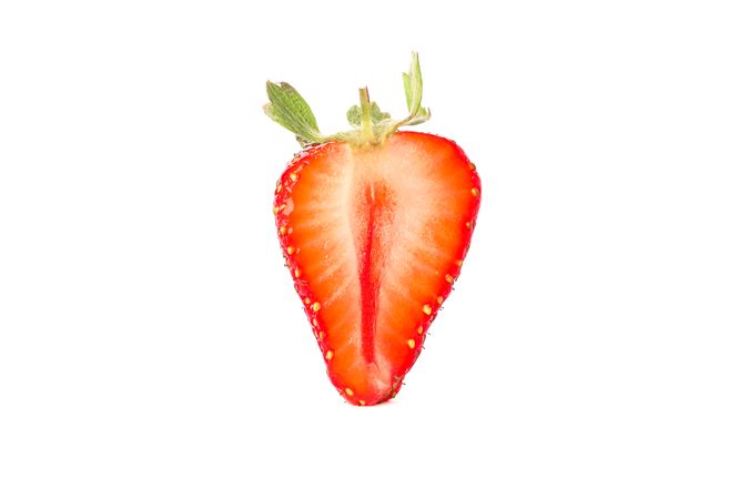 Half of strawberry isolated on light background. Summer sweet fruits and berries