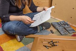 Woman reading instructions to assemble furniture