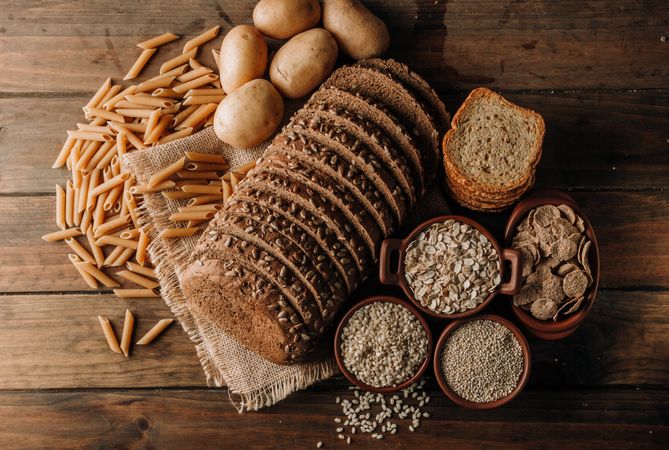 Wholegrain food pasta and freshly baked rye bread on table