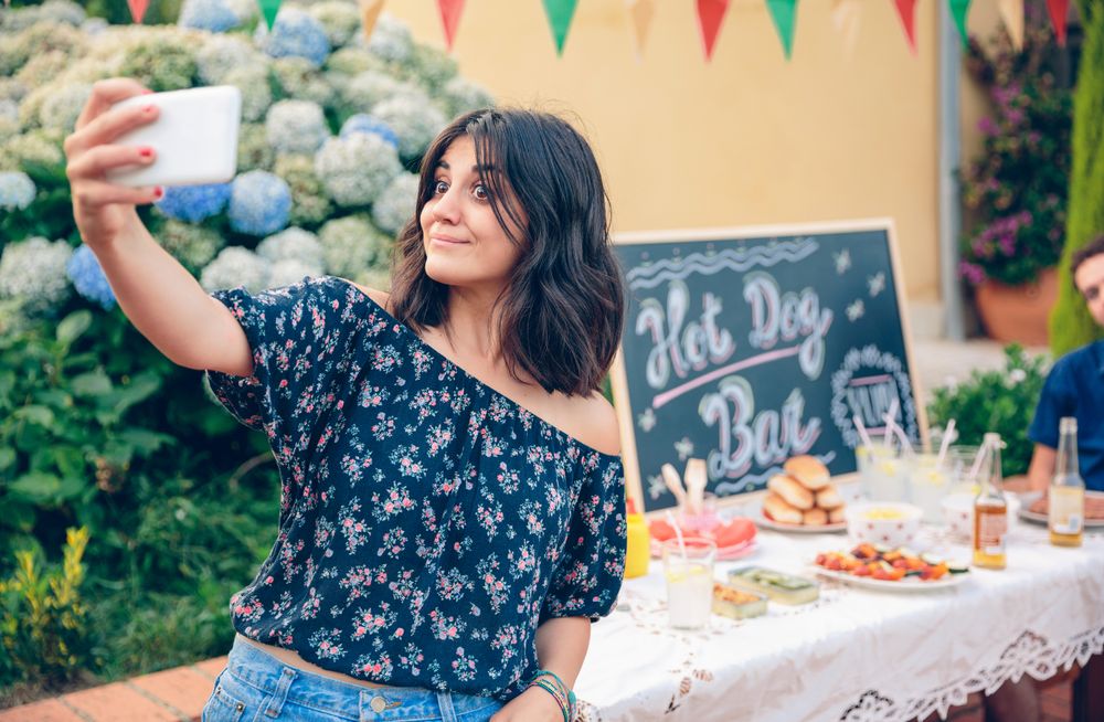 Funny young woman taking a selfie with smartphone