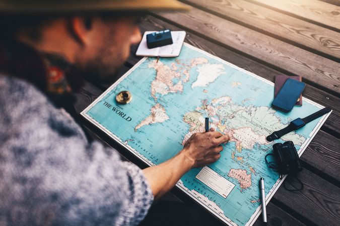 Man planning tour using world map