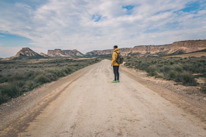 Man standing on road in desert hills