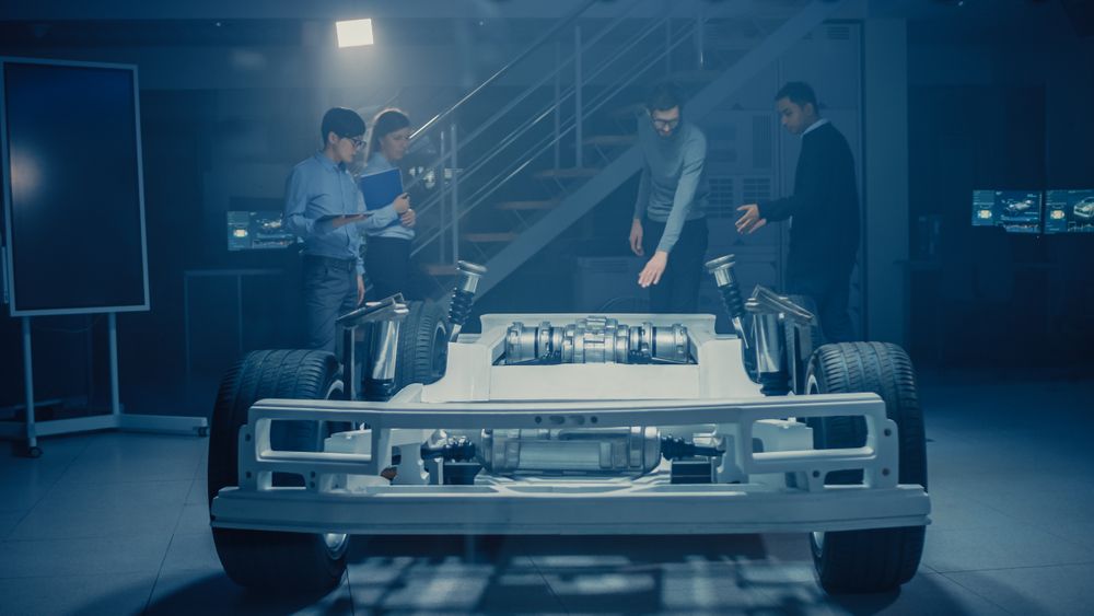 Team of Automobile Design Engineers in Automotive Innovation Facility Working on Electric Car Platform Chassis Prototype