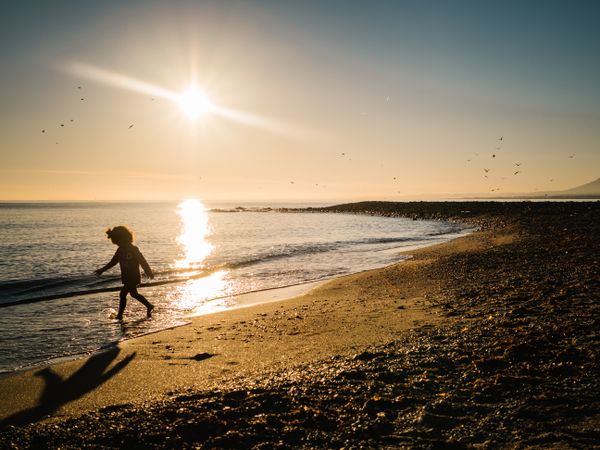 small girl walking by the beach