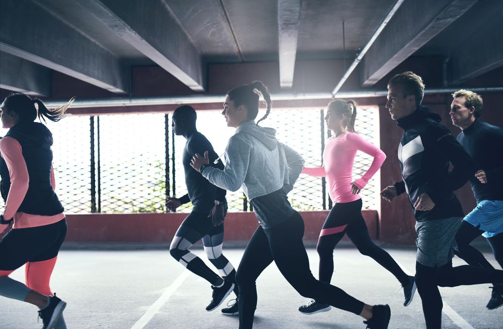 Side view of people running next to window in car park