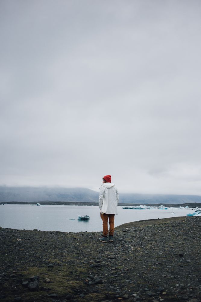 Man standing on coast on overcast day, vertical