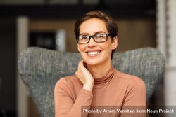 Portrait of happy woman with short hair and eyeglasses sitting in smart casual 5qoXKb