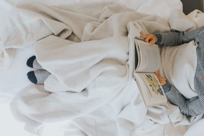 Person reading a book in bed