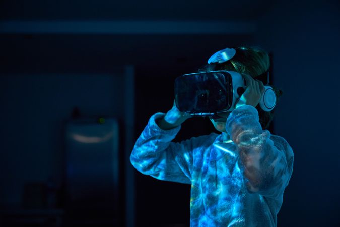 Kid watching movie in VR headset and headphones
