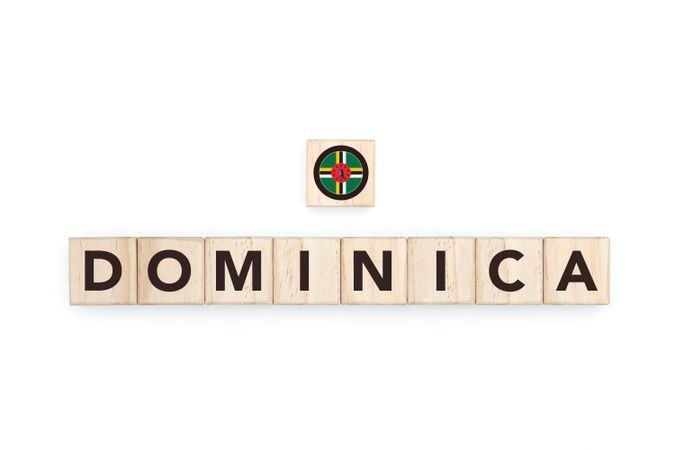 Wooden blocks bearing the name and flag of Dominica. Dominican and Caribbean Culture, national identity, travel, and geography in a copy space design.