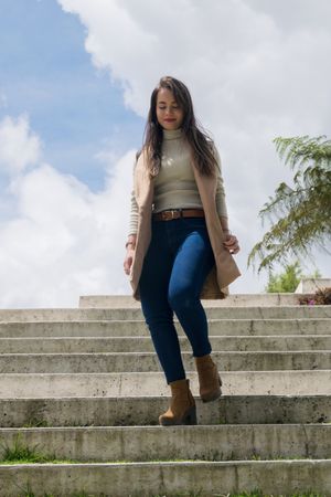 Woman in warm clothes walking down stone stairs