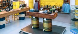 Banner of empty clothing store with clothes on counter over fuel barrels and industrial style