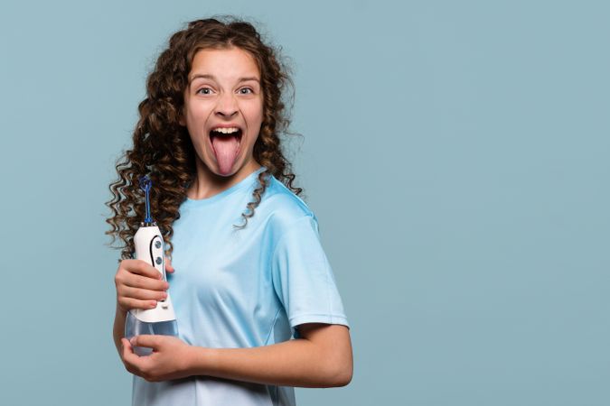 Girl sticking out tongue with oral irrigator