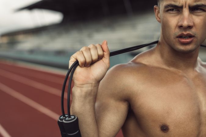 Close up of young athlete holding jump rope around neck