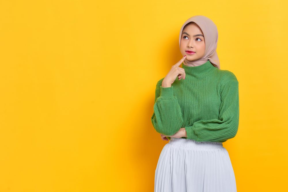 Woman in headscarf pondering something with finger on her chin