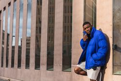 Black stylish man in warm jacket on street