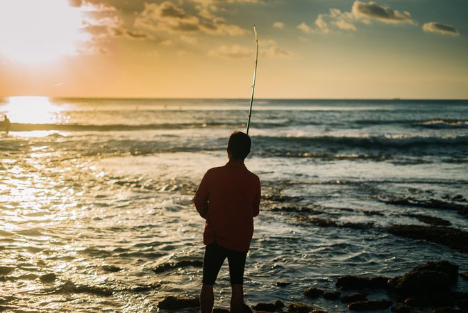 Silhouette of man fishing at Bali coast