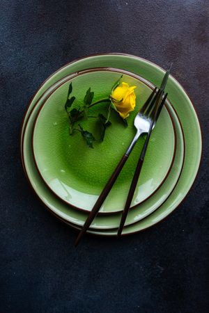 Green table setting with yellow roses with silverware