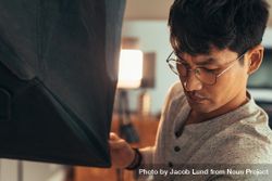 Asian male photographer adjusting lighting equipment 5zRdN5